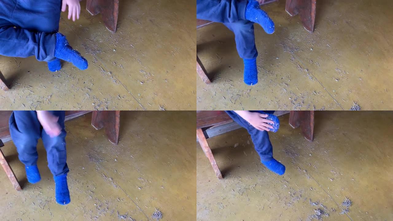 男孩清理他的蓝色袜子，里面装满了干燥的植物零件