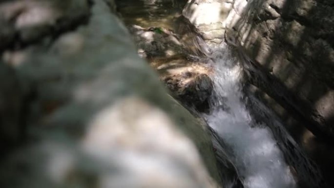 流淌着石头巨石和石头急流的野山河。小溪里快速泼水。冬天的山溪。充足的清澈溪流。