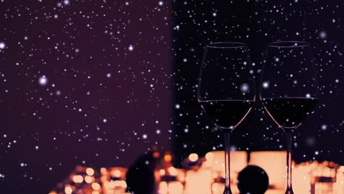 浪漫的冬季约会之夜背景，一杯葡萄酒和带有雪和节日闪光的蜡烛