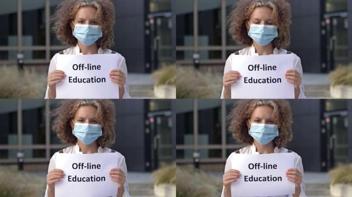 戴医用口罩的女学生举牌线下教育