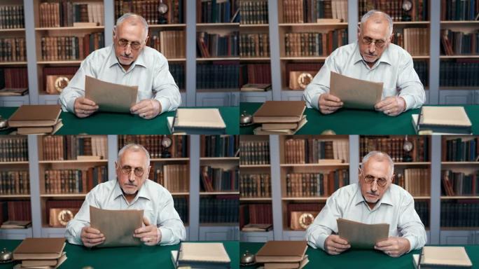 70多岁的老人博士大学教授在工作场所的图书馆阅读古旧信件文件