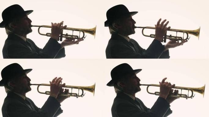 白色背景上的人的剪影在小号上演奏爵士乐，侧视图。穿着帽子和西装的音乐家吹小号
