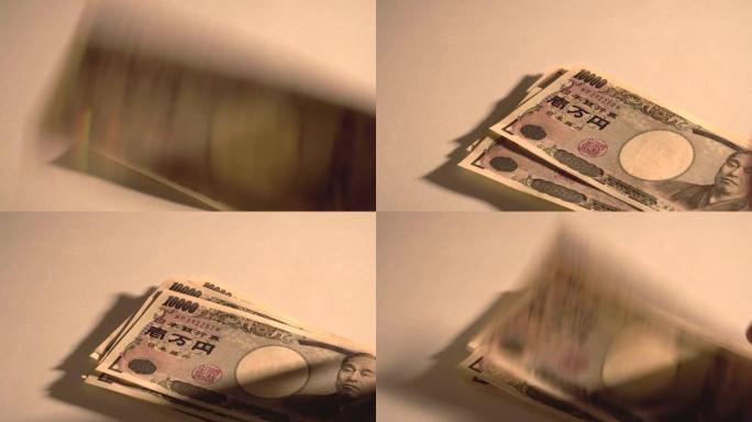在桌子上放一张10,000日元的钞票，然后数数。男人数日元钞票。