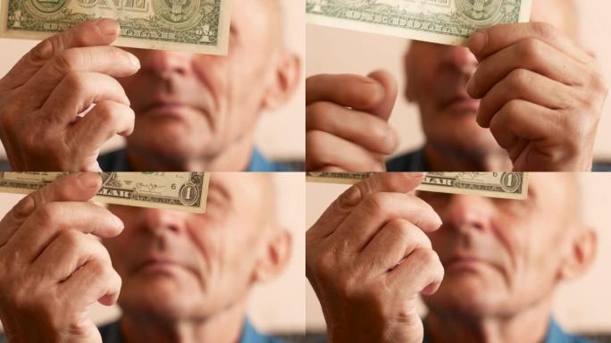 一位70-80岁的白人老人正在考虑1美元的钞票。金融危机主题。货币报价崩溃。货币市场和美元投资。选择