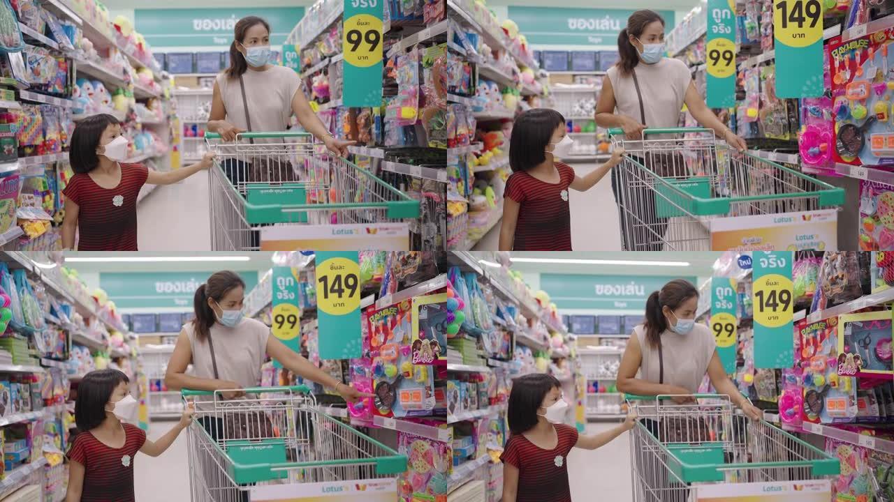 亚洲妇女和女儿在超市购物。