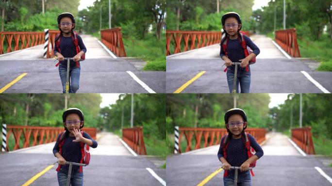 慢动作回到学校。亚洲小女孩背着书包骑着滑板车去上学