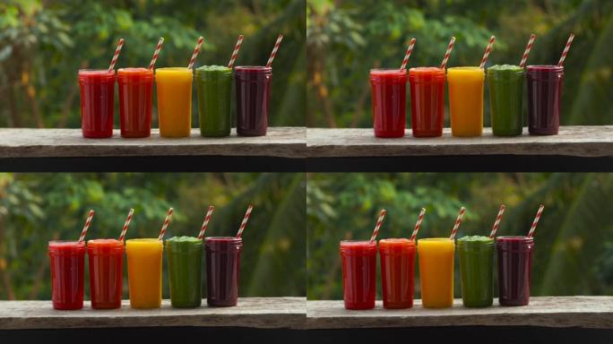 冰沙中的彩虹。西瓜、木瓜、芒果、菠菜和火龙果。冰沙，果汁，饮料，各种新鲜水果放在木桌上