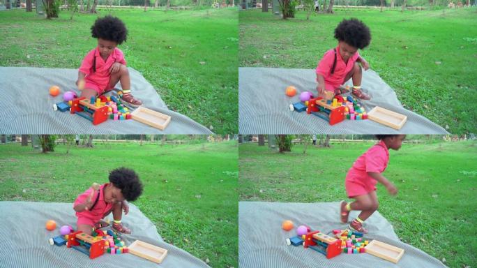 非洲男孩注意跑步，跑出前用木锤快速玩木制玩具，周末活动野餐，高视角。