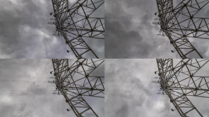 云在电塔上盘旋的延时视图。白天多云时电力线的静态拍摄，广角向上拍摄。