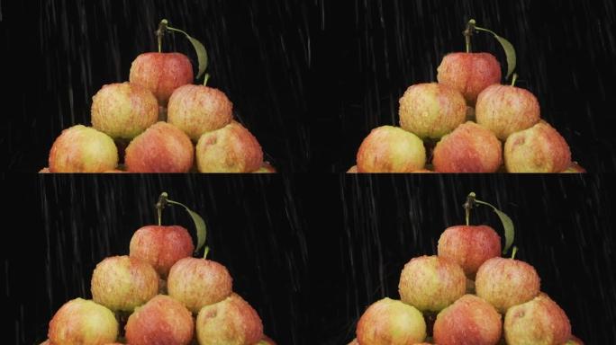 慢动作。雨滴落在一堆苹果上。水果金字塔。