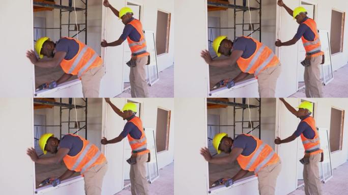 非裔美国建筑工人在木结构房屋建造过程中安装窗户
