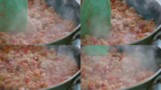 油炸肉末制作墨西哥玉米卷的过程。油炸和搅拌肉末。用硅胶刮刀搅拌鸡末。墨西哥美食