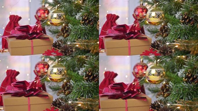 圣诞快乐。圣诞球和礼物放在圣诞树树枝和闪亮的灯光旁边的白色木桌上。降临节。贺卡。