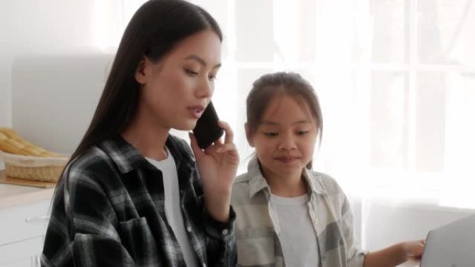 忙碌的亚洲自由职业者妈妈无视女儿在室内手机上聊天