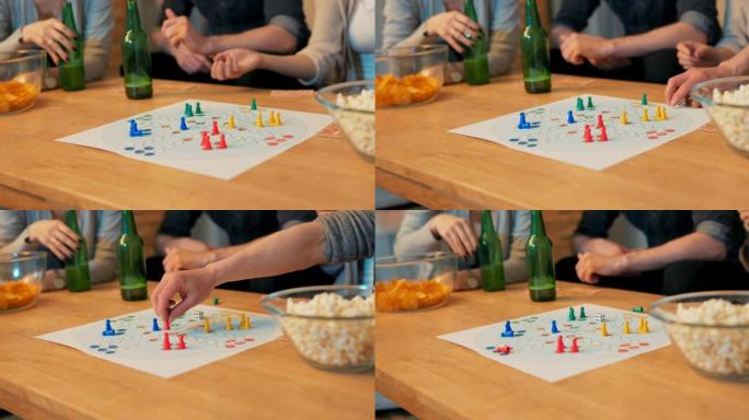 桌子的特写镜头，啤酒瓶，爆米花，筹码，游戏板在中间，棋子和纸牌排列，朋友，家人玩，扔骰子，每个人移动