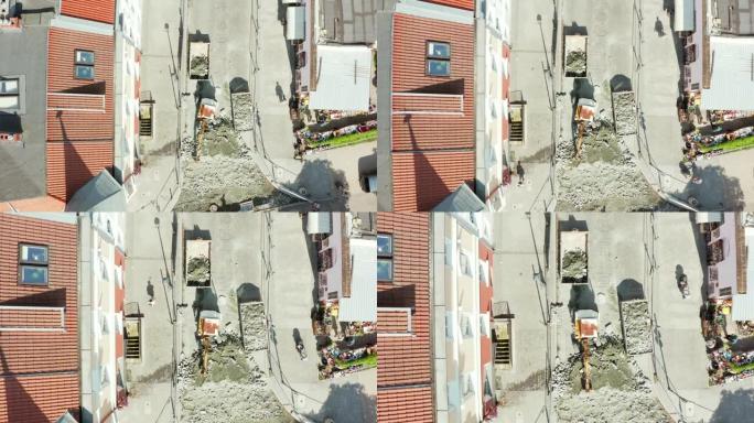 在波兰格但斯克老城区，无人驾驶飞机在挖石铺路石的小型挖掘机上俯视拍摄。修复老城区街道上的铺路石。