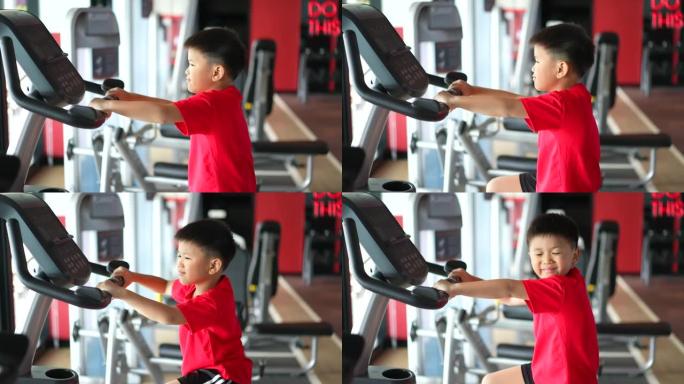 亚洲男孩在健身房用拳击和自行车锻炼微笑