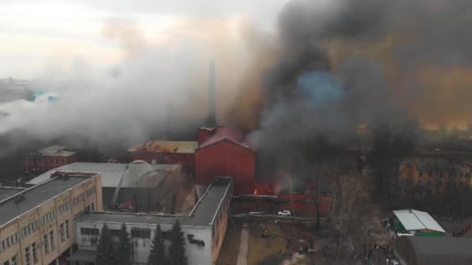 城市发生大规模大火，空中无人机俯视图砖厂大楼着火，地狱火爆炸火焰爆炸，有消防员队伍，纵火，烧毁破坏