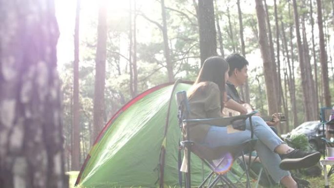 快乐的旅行者在森林里演奏音乐和露营