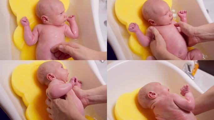 母亲在洗澡时给一个新生婴儿洗澡。
