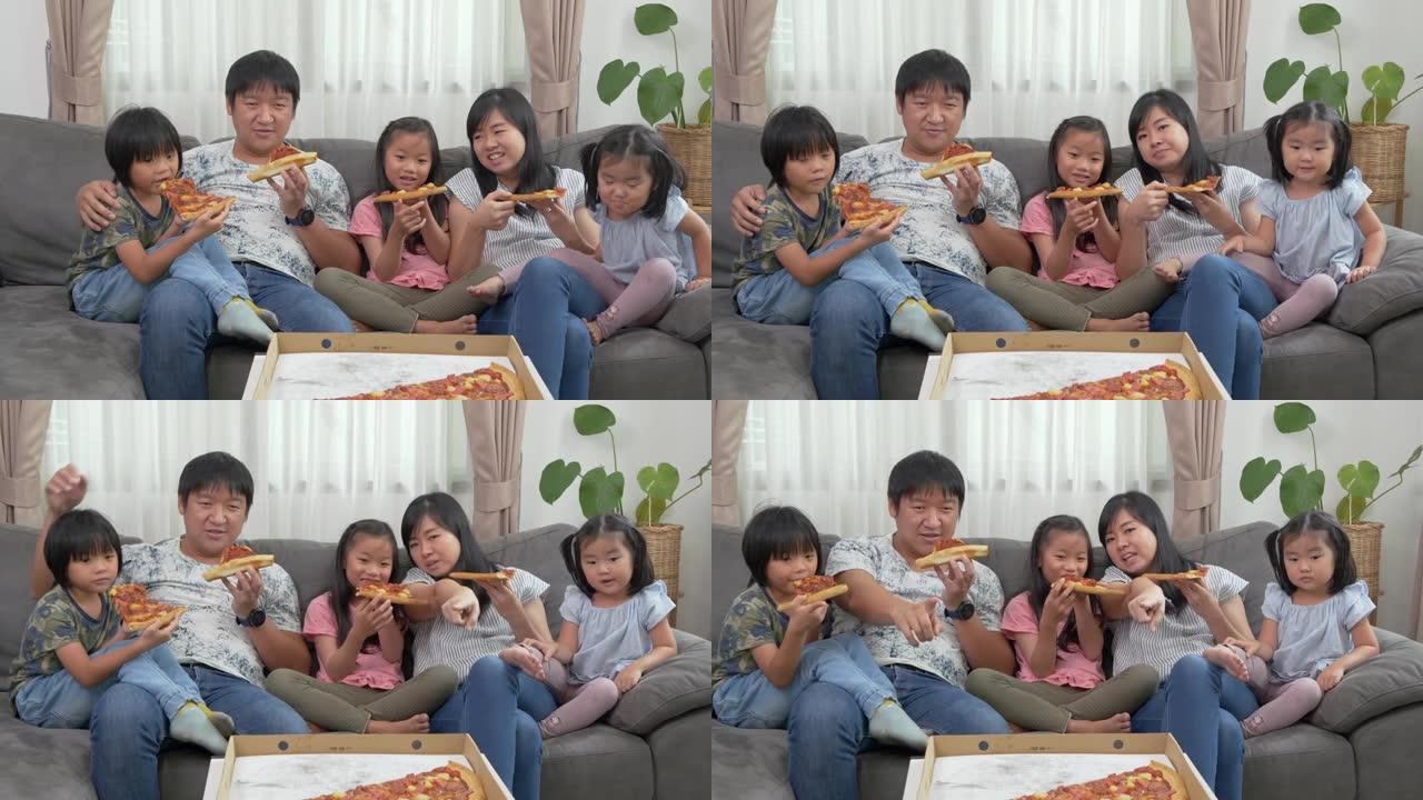 一家人坐在沙发上吃披萨，看电视