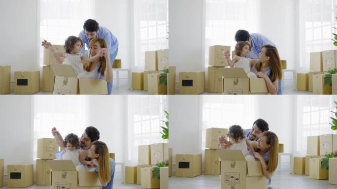 土耳其女儿和亚洲母亲玩箱子车，在硬纸板间的房子上被拉丁父亲以深情送出的积极情感所感动。一个多民族家庭