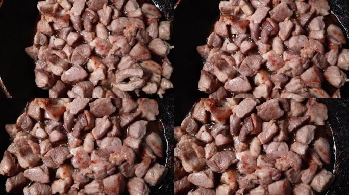 在煎锅中煎炸时的猪肉块，俯视图