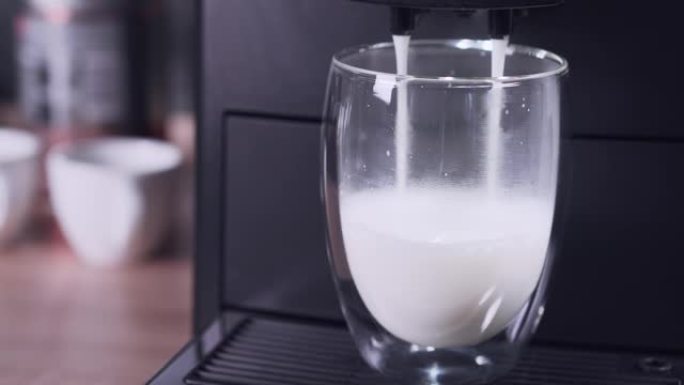 自动咖啡机为拿铁准备牛奶泡沫。咖啡饮料加牛奶，准备。