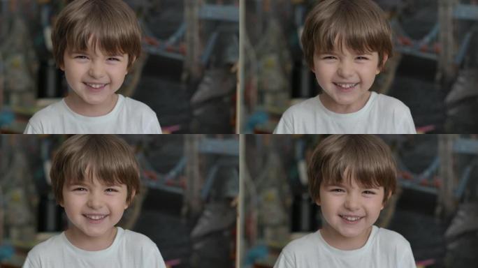 快乐的小孩大笑的特写肖像。小男孩在室内特写大笑。小男孩看着镜头微笑的肖像。面对有趣的沉思孩子。慢动作