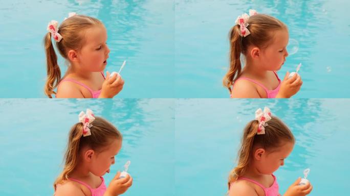 4-5岁快乐的小女孩，扎着马尾辫，穿着粉色泳衣，暑假在泳池里吹肥皂球
