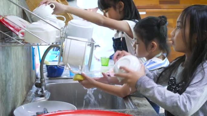 孩子们在学校的厨房洗碗，孩子们在家里一起帮忙做家务