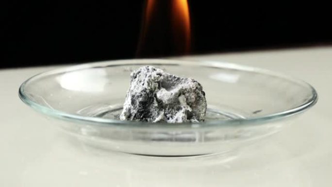 电石或CaC2的慢动作镜头与水接触会发生反应，并产生易燃的乙炔气体。乙炔气体燃烧产生的火灾