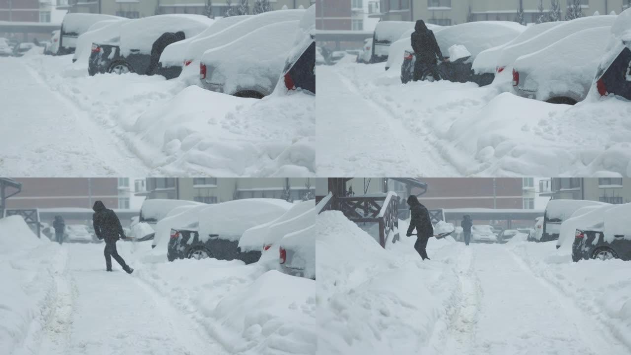一个人清除了他的车积雪。用铁锹清除停车场的积雪
