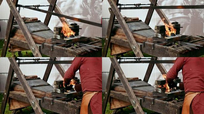 铁匠给火盆的风箱充气，并用钳子从火中取出铁水部分