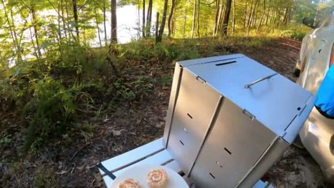 带露营烤箱在湖边的披萨石上滚动