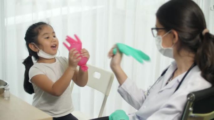 医生给小女孩打疫苗前和小女孩玩耍，注射冠状病毒疫苗