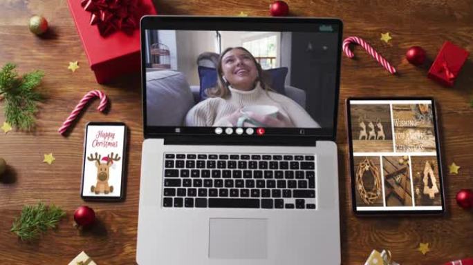 快乐的白人妇女在笔记本电脑上进行视频通话，配备智能手机，平板电脑和装饰品