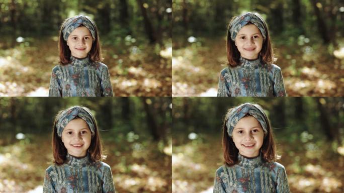 无忧无虑快乐小女孩的肖像真实照片在一个炎热的秋天，在一个黄色的公园里玩得很开心。理念: 自由、童年、