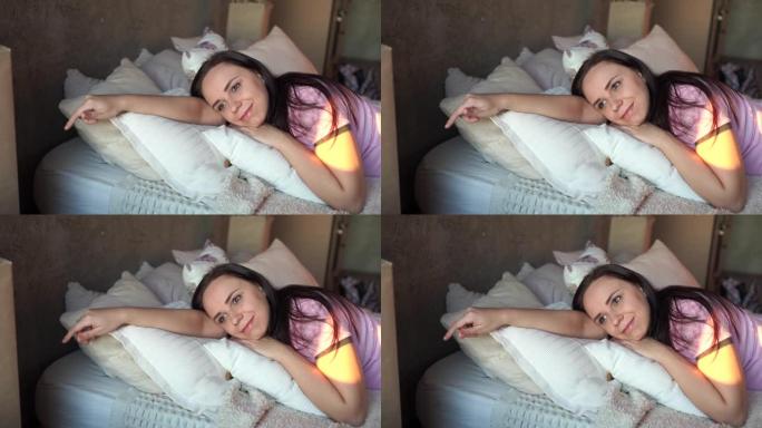 早上穿着睡衣躺在床上拥抱枕头的年轻漂亮女人的肖像。成年女士的特写镜头休息并梦dream以求