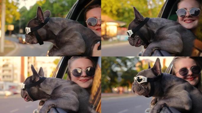 关心和可爱的女孩，抱着她的狗，这样他就可以在开车时带着防护眼镜探索城市