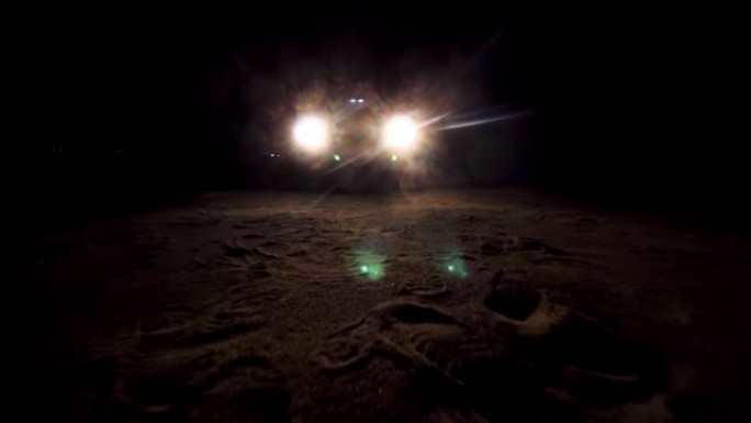 夜间汽车的前灯，照亮前方的沙面