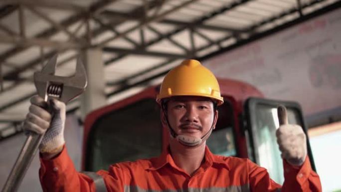 亚洲机械师的肖像与维修设备站在汽车维修服务中心的技术员或工程师专业为客户工作。