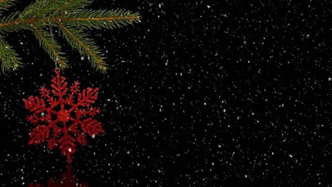 黑色背景上圣诞树上的红色圣诞装饰上的雪的动画