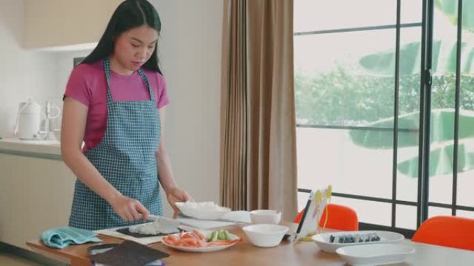 东南亚女人在家做寿司卷。