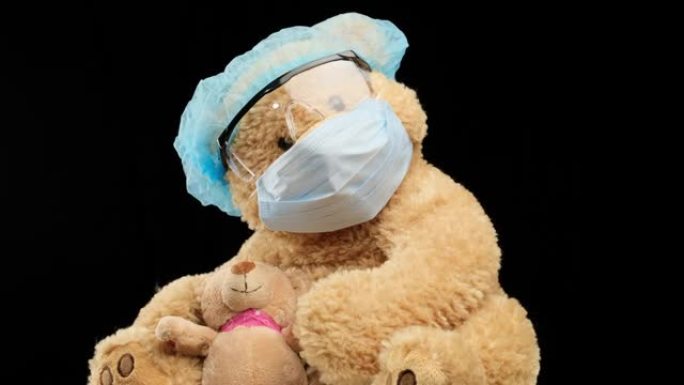 棕色泰迪熊坐在保护性塑料眼镜中，这是一种医用一次性口罩