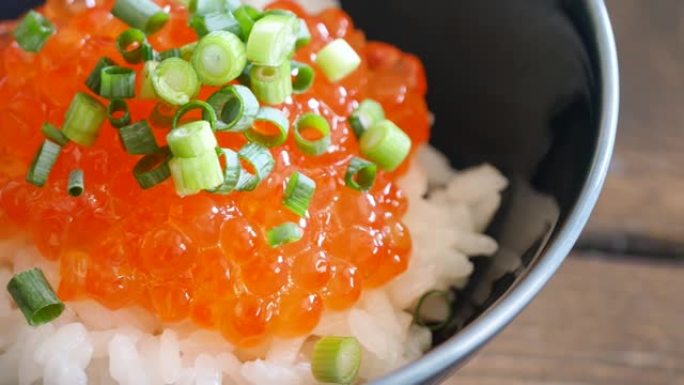 鲜熟米饭上三文鱼鱼子的特写视频。
