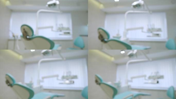 模糊的现代牙科实践。牙科医生使用的蓝色牙科椅和其他配件，军医灯
