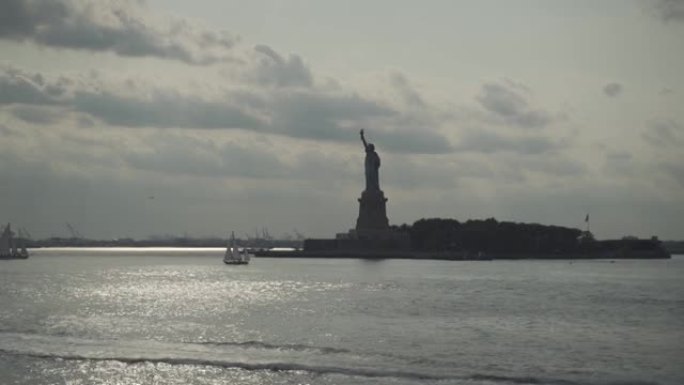 自由女神像和日落时的帆船