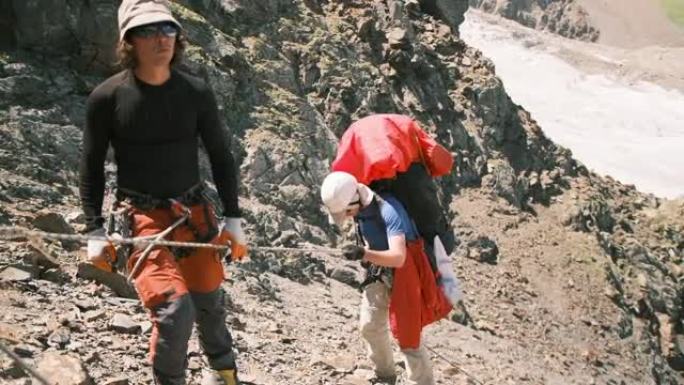 登山者在绑扎系统和绳索的帮助下，沿着山中艰难的路段下降。