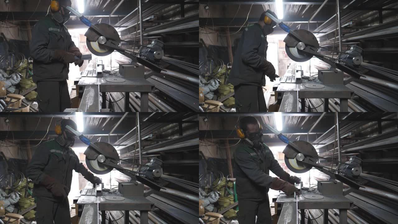 男子在安全保护磨损使用锯切割机来研磨金属细节。车库里有圆锯锯钢的家伙。工业专业工人看到金属。火花从铁
